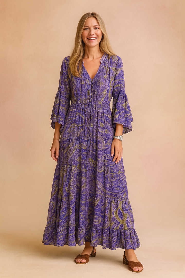 Bohemian women's maxi dress featuring a flowy tiered design, elegant V-neck, and long paisley flared sleeves.