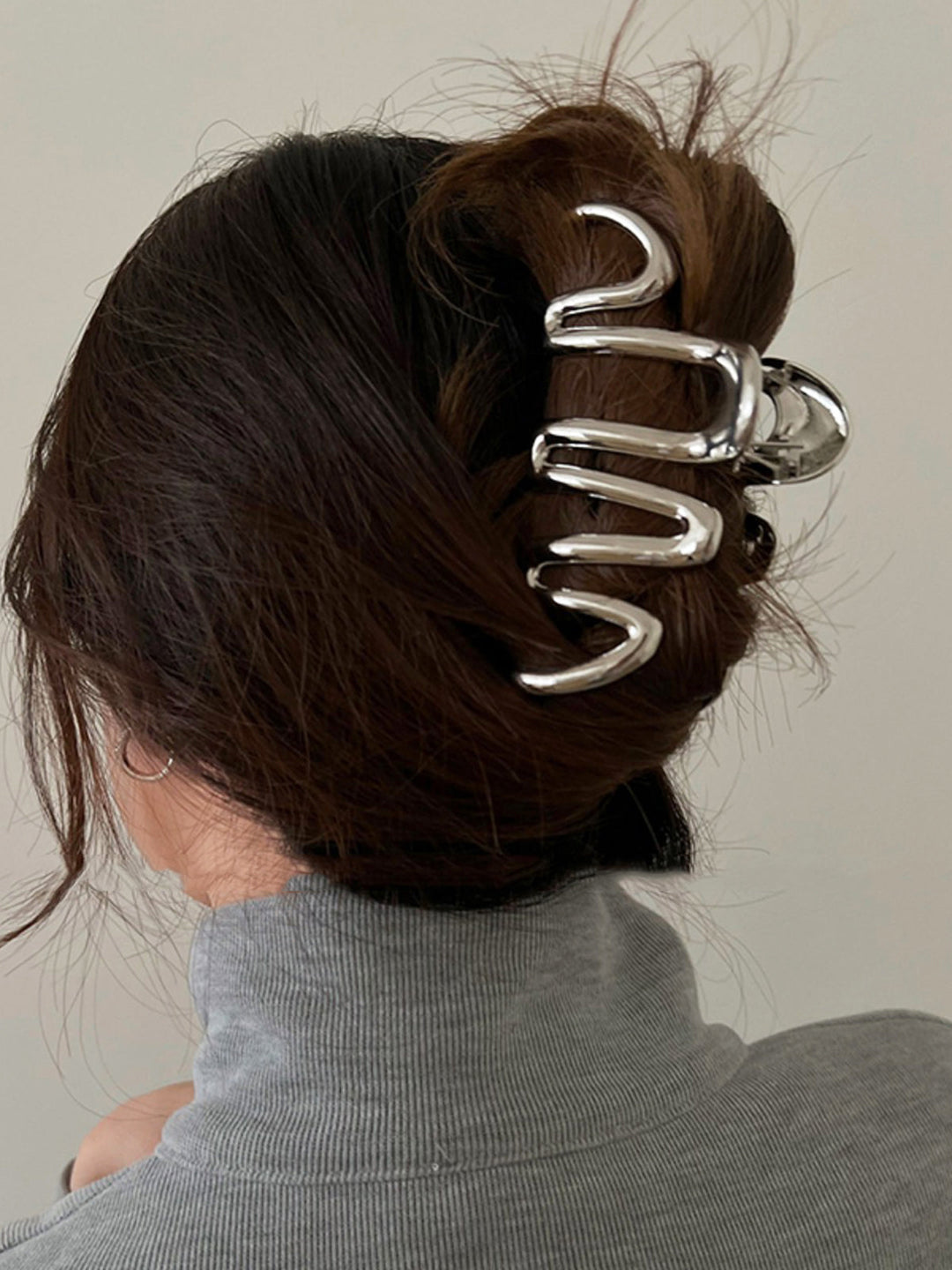 Elegant silver Fluid Wave hair claw for women, perfect for stylish updos & hair styling. Metal hair accessory.