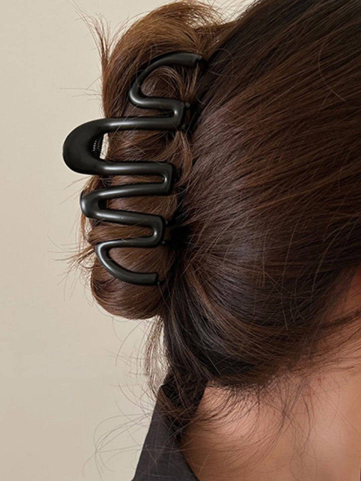 Black Fluid Wave hair claw, a chic women's hair accessory for elegant updos & versatile hair styling.
