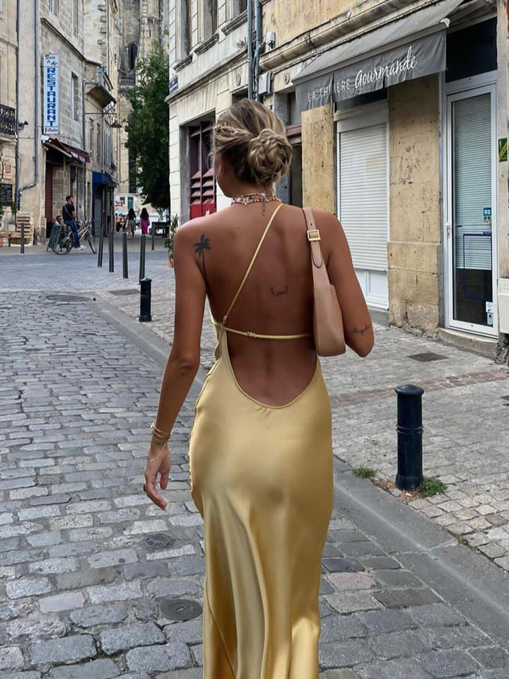 Sophisticated wedding guest maxi dress, featuring an elegant open back and formal style.