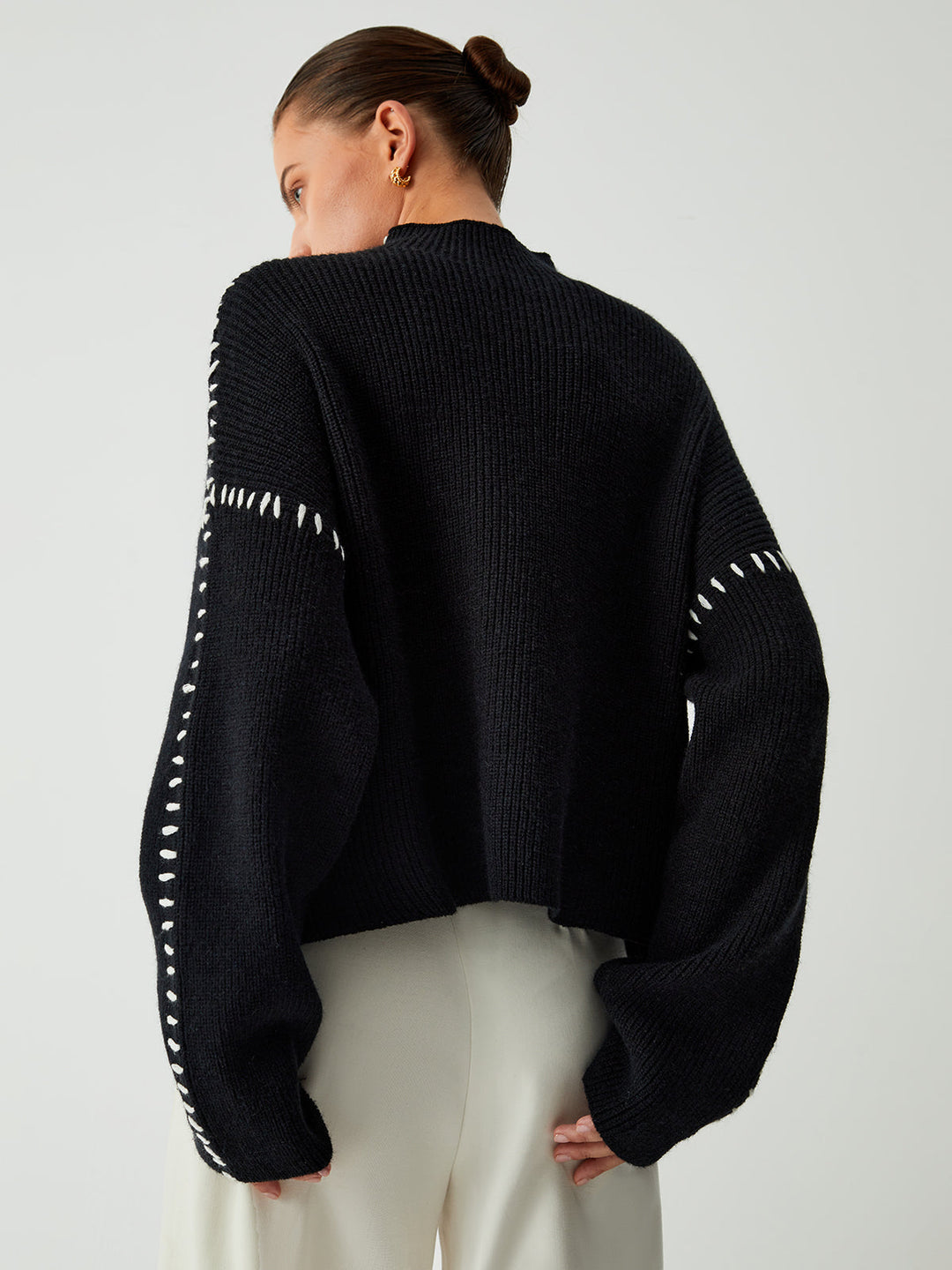 Black oversized women's mock neck sweater, a stylish and warm top for effortless elegance and comfort.