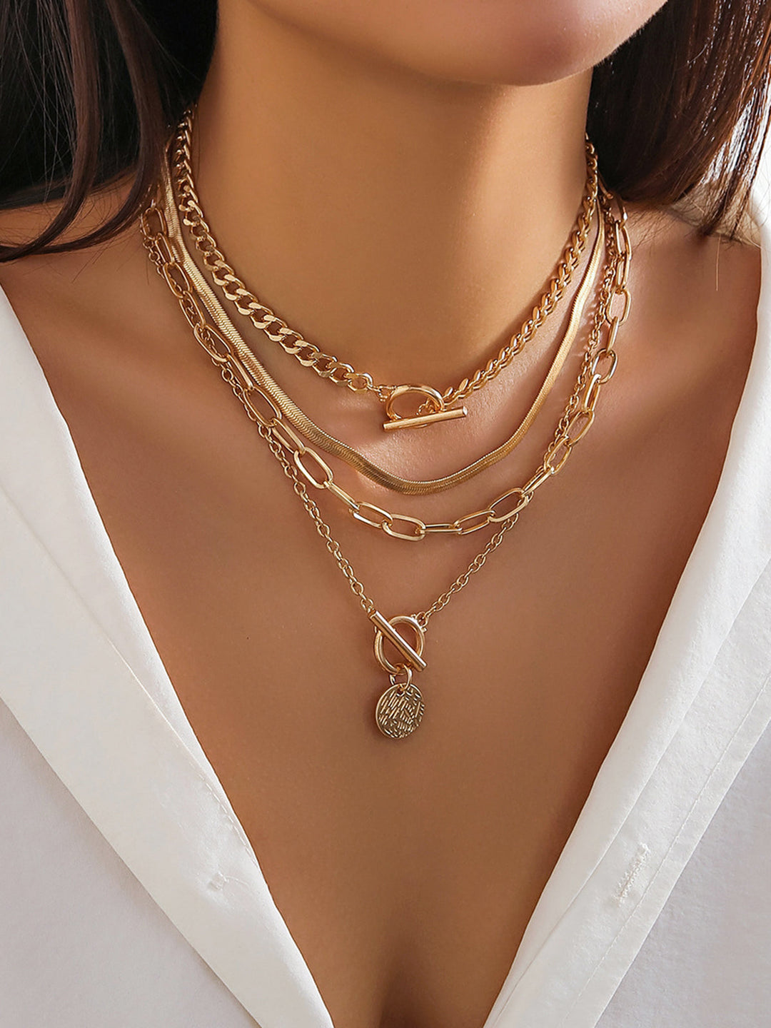 Women's gold layered necklace set with delicate coin pendants. Elegant fashion accessory for a sophisticated look.