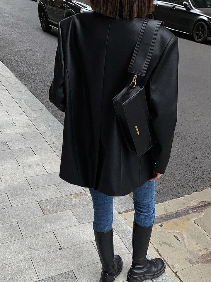 Black oversized women's blazer. Stylish statement jacket with lapel collar for chic layering & versatile fashion.