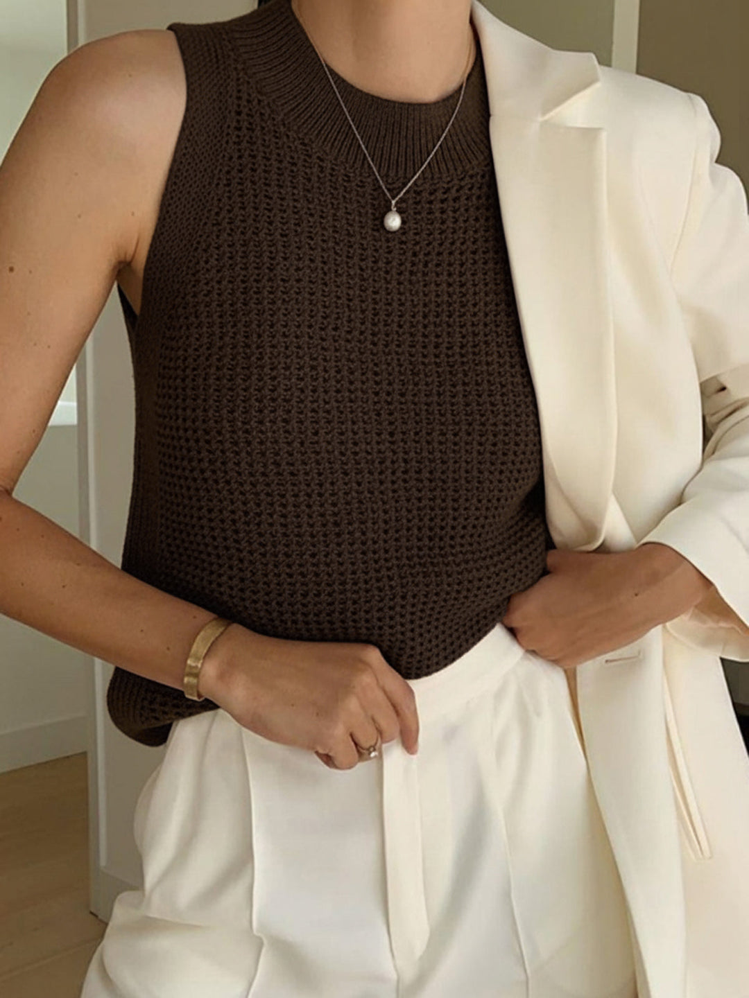 Women's knit sleeveless tank top with trendy cut-out detail, a versatile summer fashion layering piece.