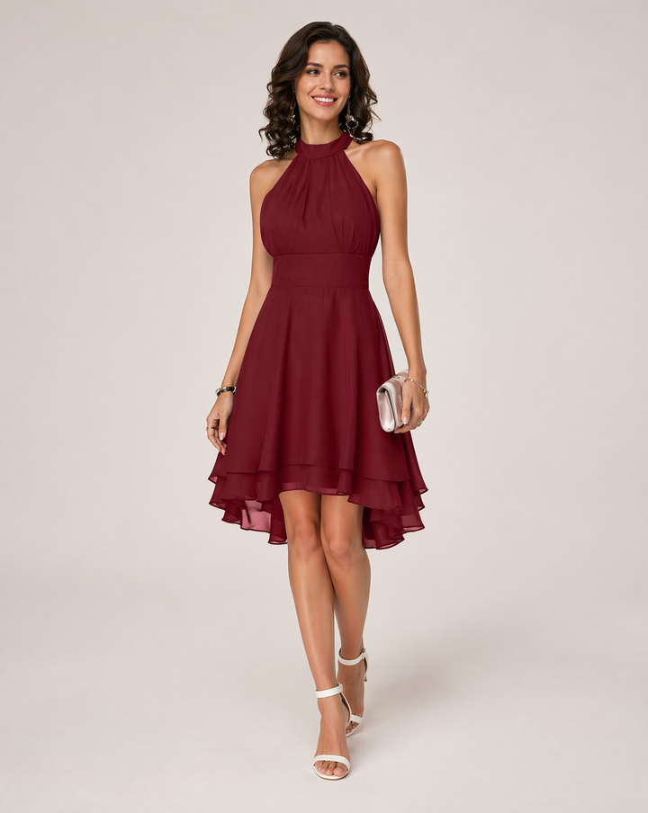 Party-ready women's midi dress: elegant halterneck, flowy pleated tiered skirt, and asymmetric hem.
