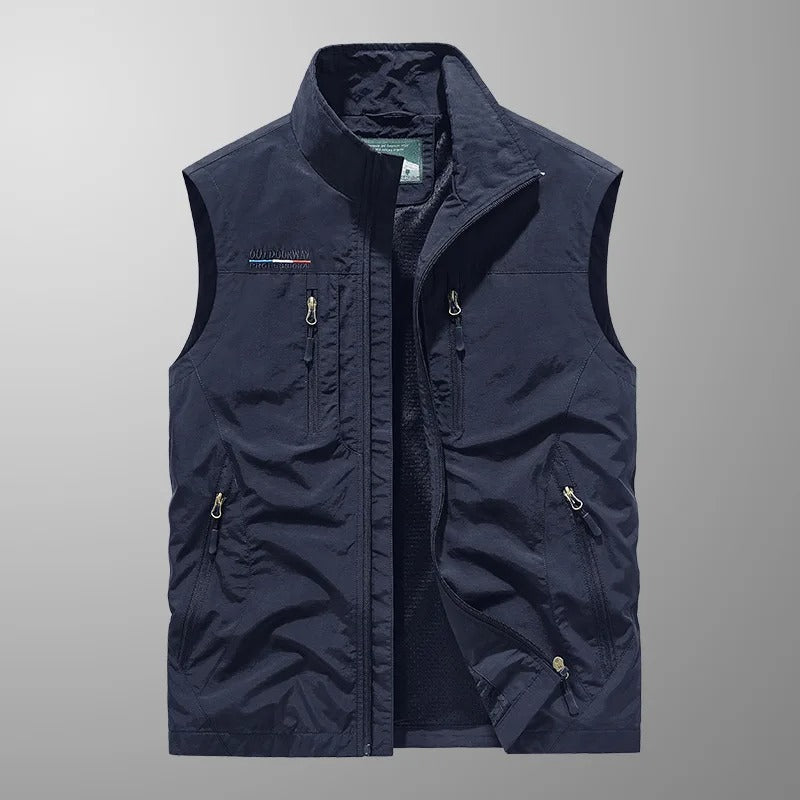 Man wearing a lightweight sleeveless cargo vest, perfect for outdoor hiking & travel, with functional zip pockets.