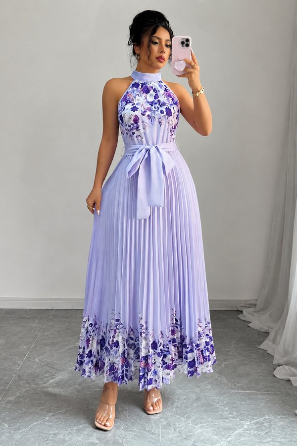 Side profile of an elegant women's floral pleated midi dress, showcasing its flowy design and tie-waist.