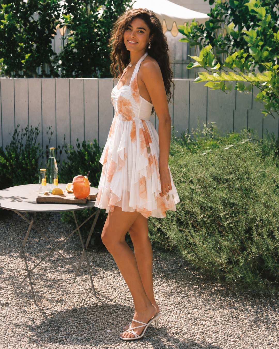 Women's sleeveless floral halter mini dress, showcasing the elegant summer style and ruffle hem detail.