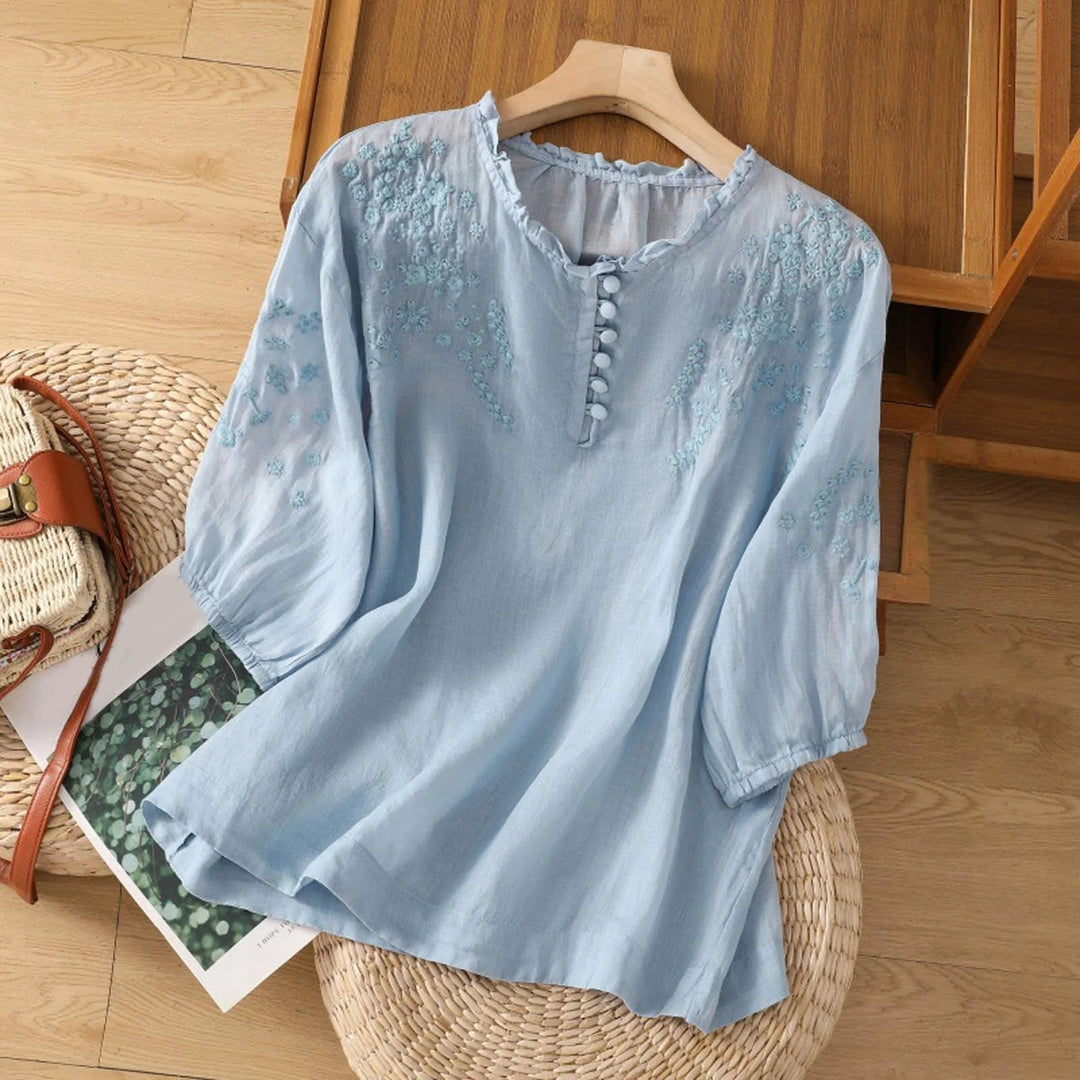 Women's floral embroidered blouse with ruffle neck, perfect for elegant spring and summer fashion.