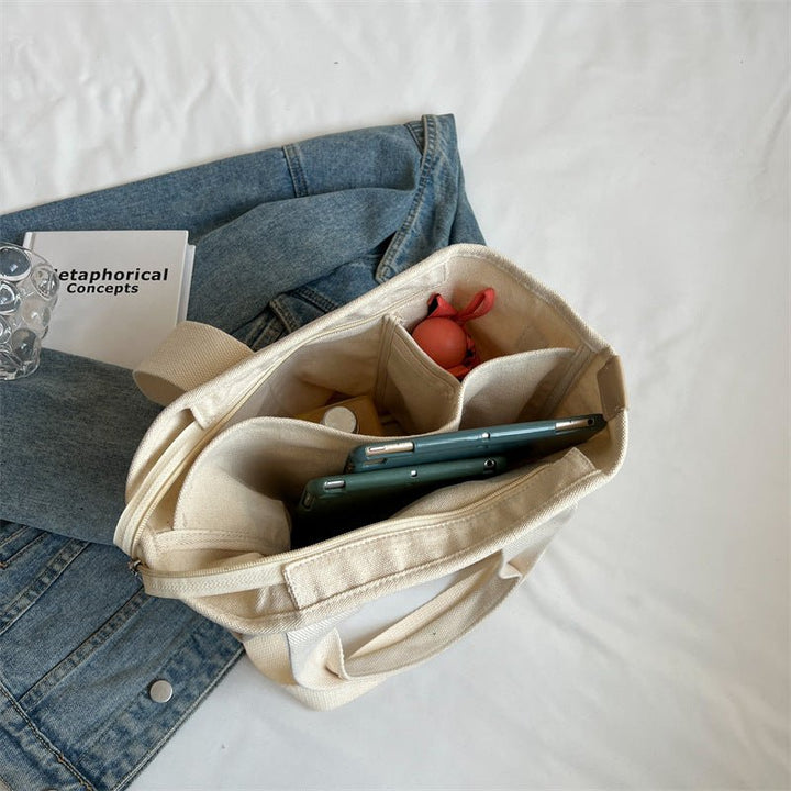 Stylish women's canvas tote bag, a trendy fashion accessory with adjustable strap for versatile wear.