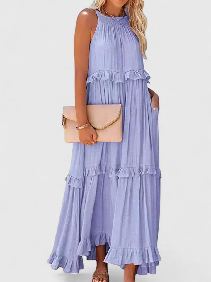 Detailed shot of elegant ruffles and flowy fabric of a women's white summer maxi dress.