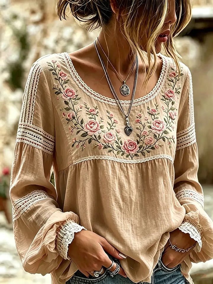 Casual spring/summer blouse for women, featuring intricate floral embroidery and relaxed long sleeves.