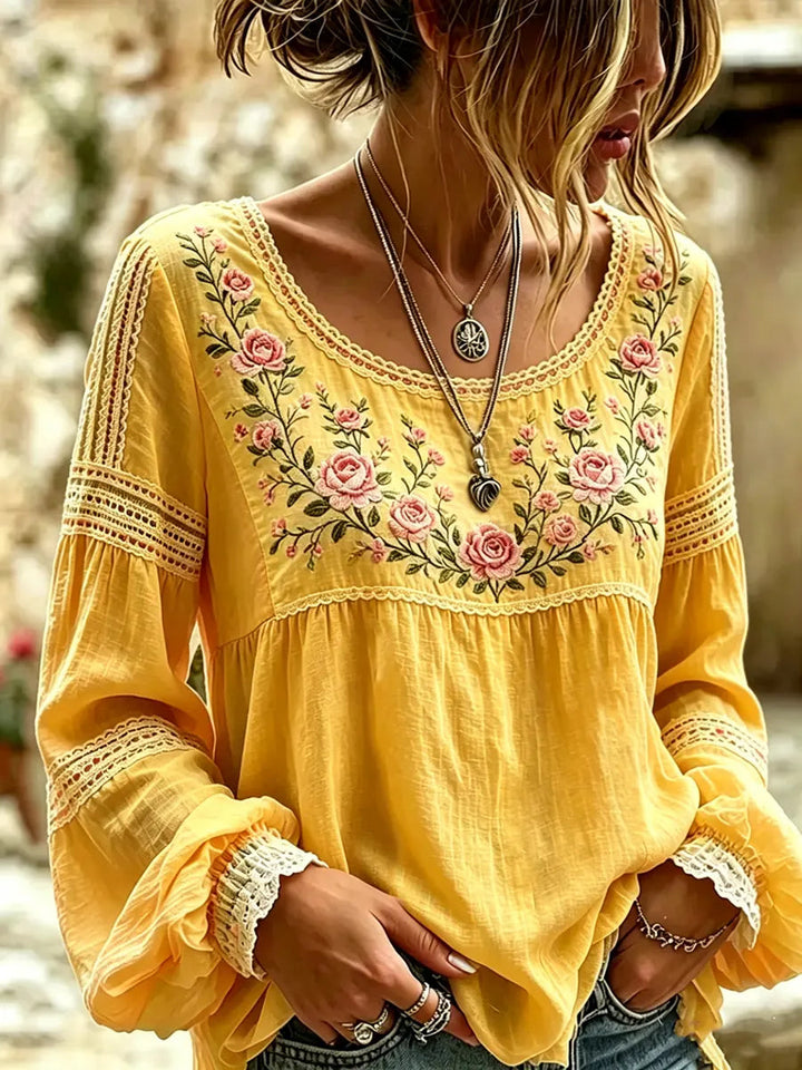 Detailed close-up of a women's floral embroidered blouse, showcasing relaxed long sleeves and elegant design.