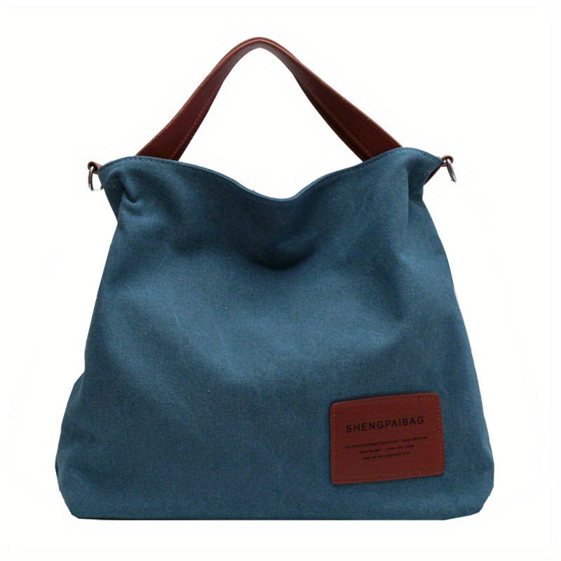 Versatile women's black canvas shoulder tote bag, large and stylish with an adjustable strap for comfort.