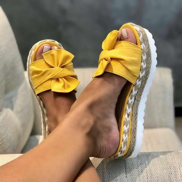 Chic women's bow wedge sandals with a woven platform, offering a blend of elegance and casual summer style.