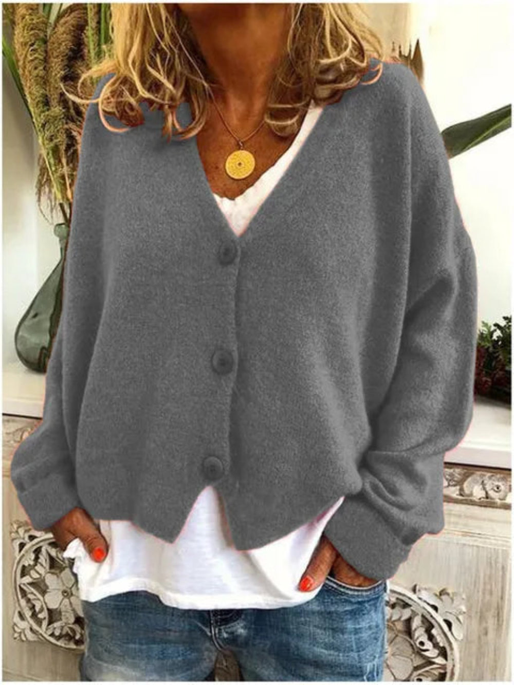 Women's V-neck knit cardigan styled casually, highlighting its versatile button-front and comfortable long sleeves.