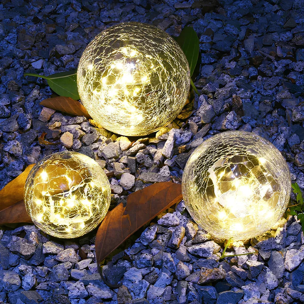Durable crackled glass solar orb with warm white LED light, ideal outdoor decor.