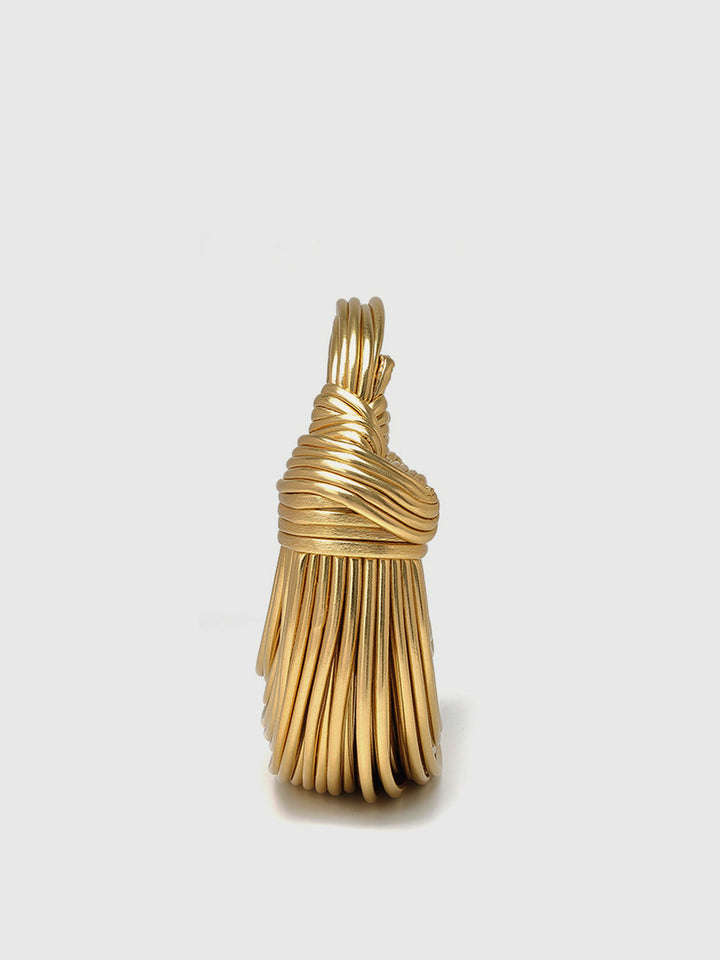 Close-up of a women's golden twisted hoop handbag, showcasing its unique design and luxurious texture.