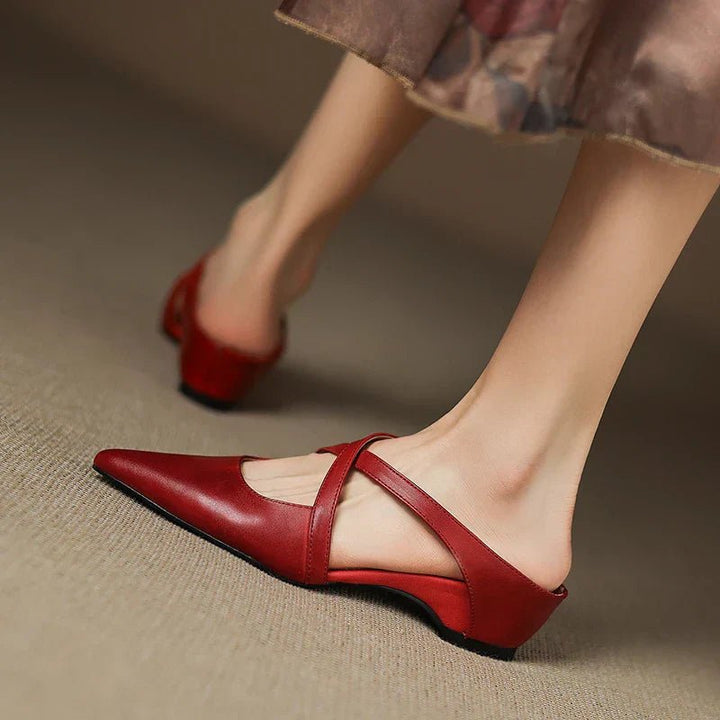 Women's slip-on Eloise mules with sophisticated pointed toe and elegant cross-strap design.