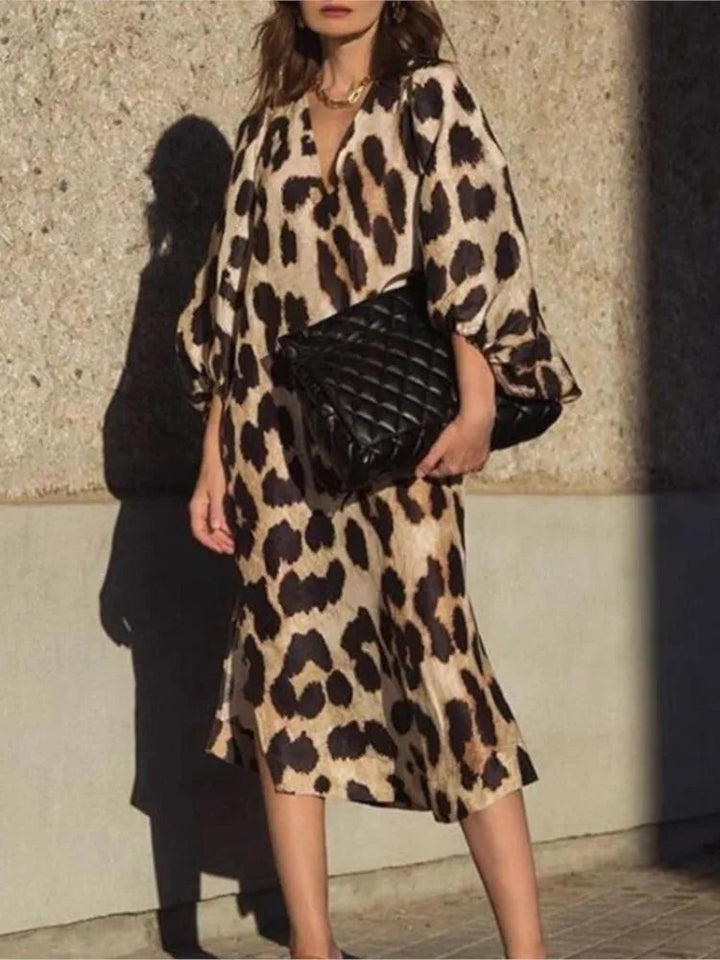 Woman models a flowing leopard print midi dress, embodying chic day-to-night style.