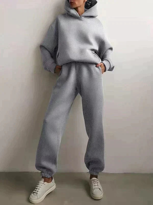 Fashionable grey women's activewear set: comfy hoodie and matching joggers for fitness or relaxation.