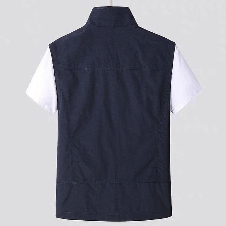 Close-up of men's water-resistant utility vest showing stand collar, sturdy zipper, and durable fabric for layering.