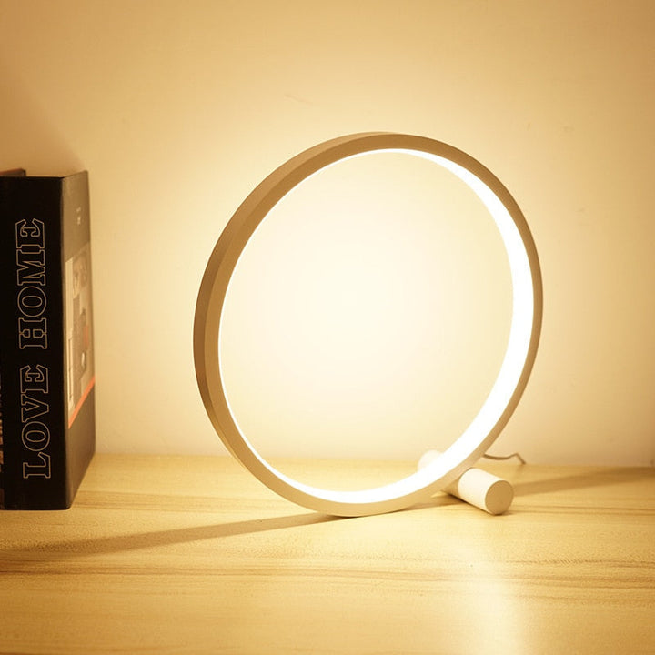Sleek halo ring LED table lamp, dimmable for bedroom or living room, offering modern ambient lighting.