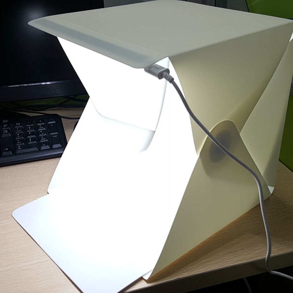 White foldable light box for product photography, providing even LED illumination for small items.