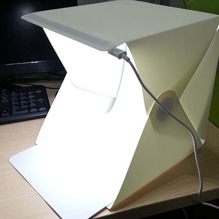 White foldable light box for product photography, providing even LED illumination for small items.