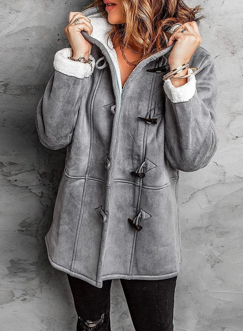 Warm women's winter jacket with hood and toggle details. Perfect for cozy, cold weather outfits.