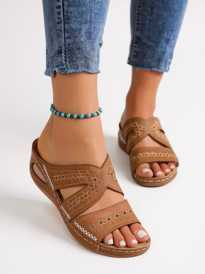 Stylish women's slide sandals with intricate embroidery, perfect slip-on footwear.