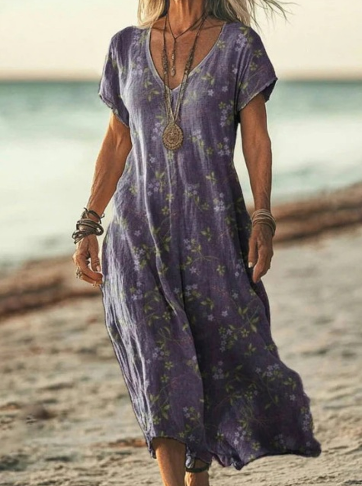 Flat lay of women's floral print midi dress. Highlights vibrant pattern, midi length & comfortable elegant summer style.