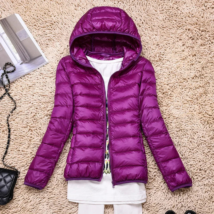 Women's ultralight puffer jacket hanging, displaying its sleek design. A must-have winter coat.