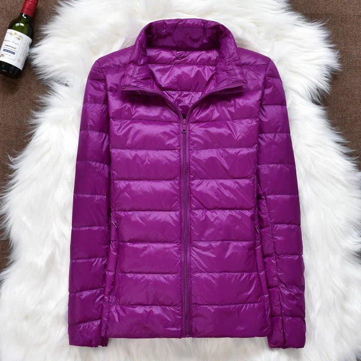 Folded women's packable puffer jacket ready for travel. Lightweight and compact outerwear.