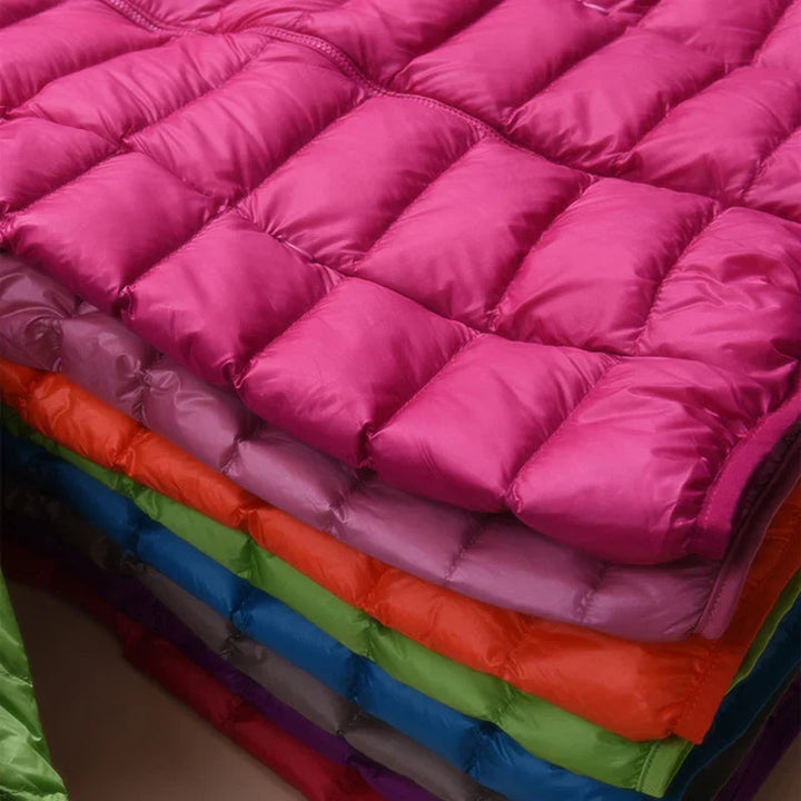 Women's packable puffer jacket in a casual city setting. Stylish, lightweight, warm for travel.