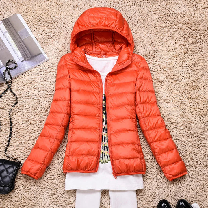 Woman wearing a hooded ultralight puffer jacket, side view. Great warm outerwear for fall & winter.