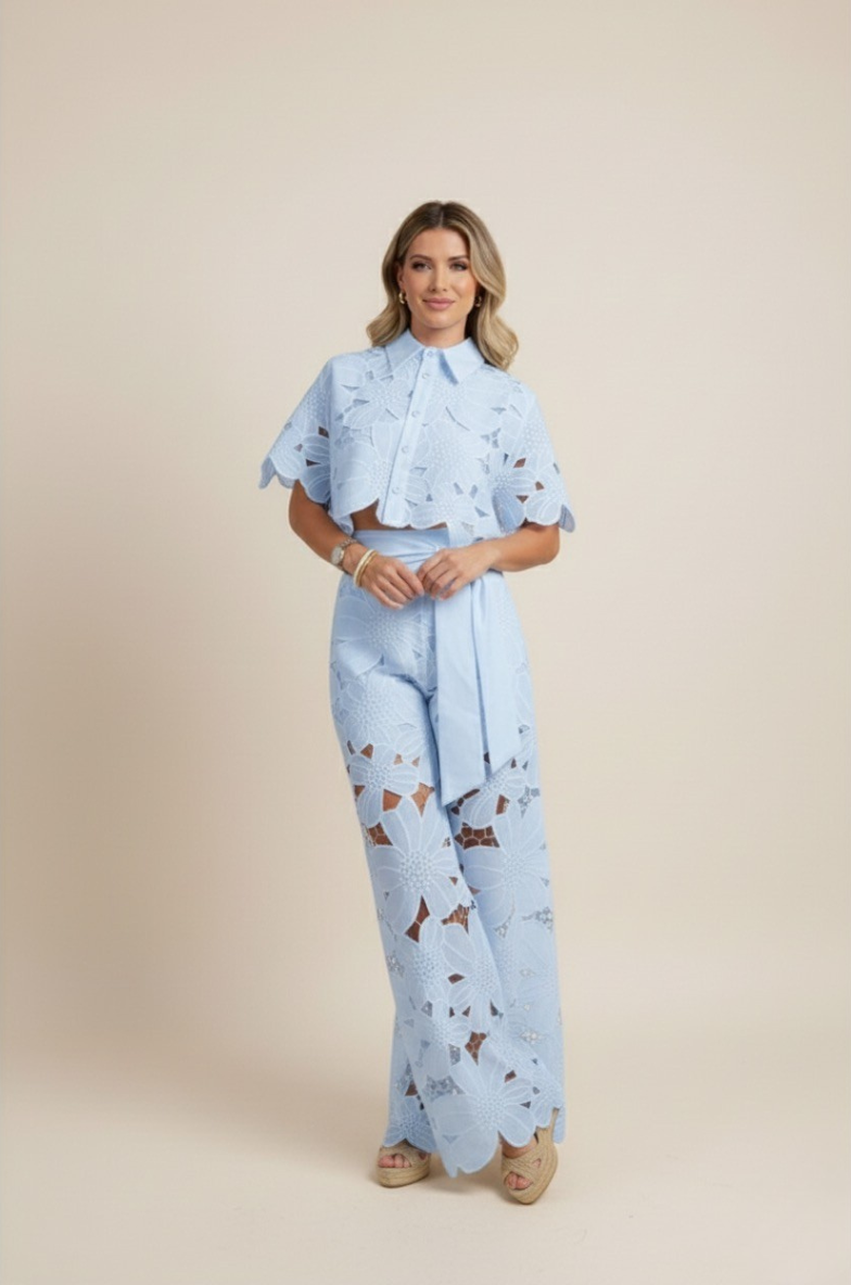 Resort wear women's floral ensemble with embroidered top & wide-leg pants. Elegant summer fashion.