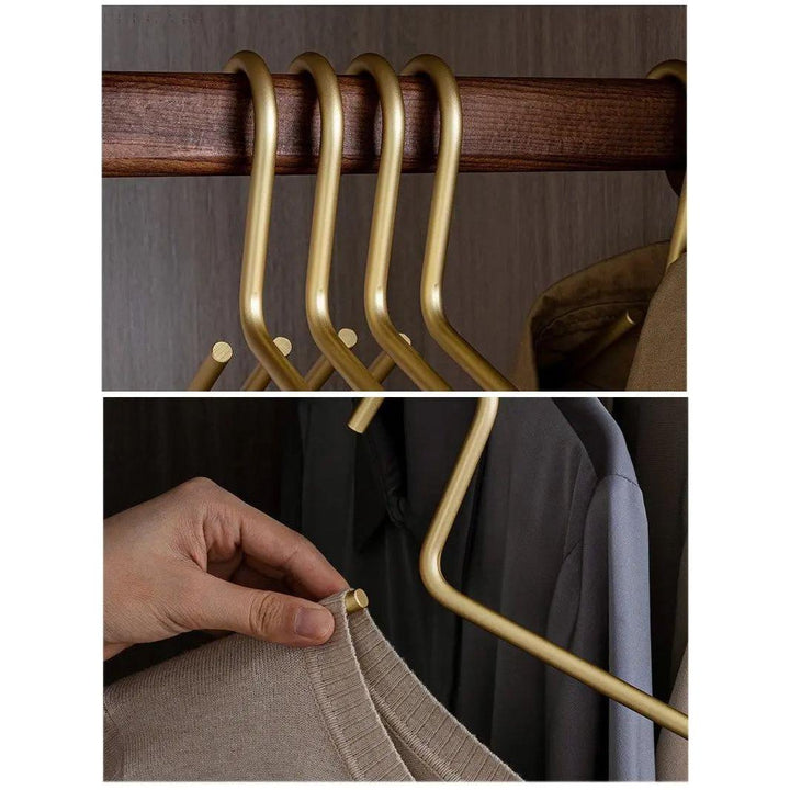 Modern wardrobe organized with sleek, non-slip gold metal hangers. Enhances clothes storage & creates an elegant home closet.