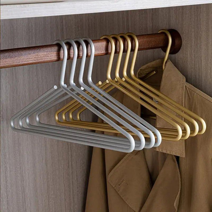 Stack of luxury gold metal hangers, showcasing slim profile for maximizing closet space. Non-slip for efficient wardrobe organization.