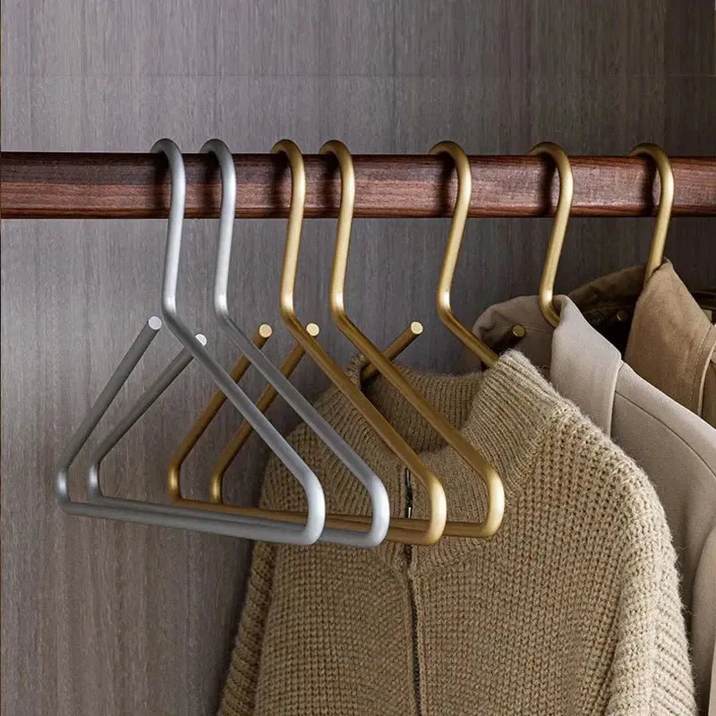 Elegant silver non-slip metal hangers safely holding delicate garments, preventing slips & creases. Premium clothes storage.