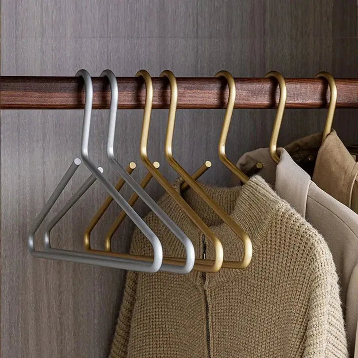 Elegant silver non-slip metal hangers safely holding delicate garments, preventing slips & creases. Premium clothes storage.