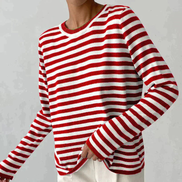 Bold striped women's knit sweater. Long sleeve crew neck pullover, a classic pattern for modern autumn fashion.