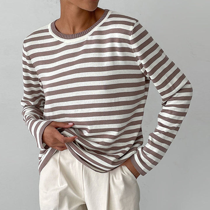 Close-up: Cozy women's striped knit sweater with soft texture. Long sleeve crew neck for winter comfort and style.