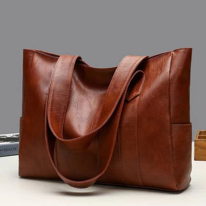 Front view of a women's classic large vintage leather tote bag with sturdy handles, versatile shoulder bag.