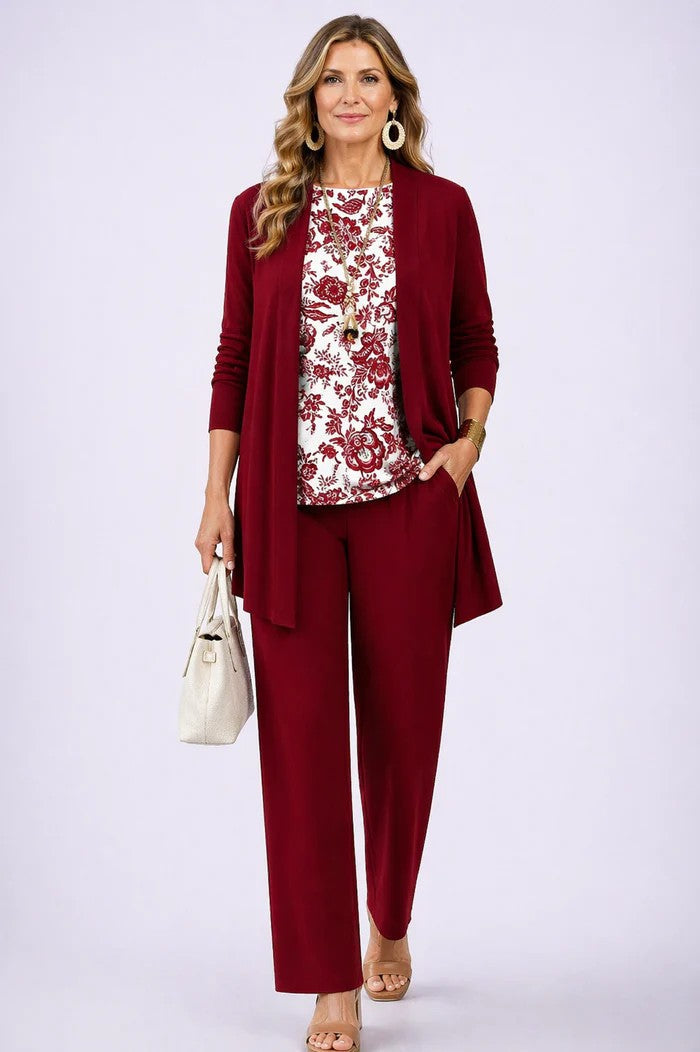 Model wearing women's three-piece set, styled casually. Printed pants, longline jacket, top for comfortable chic.