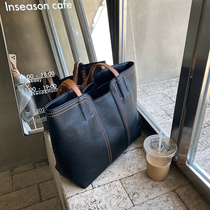 Stylish women's minimalist vegan leather tote bag, large capacity, designed for shoulder carry & travel.