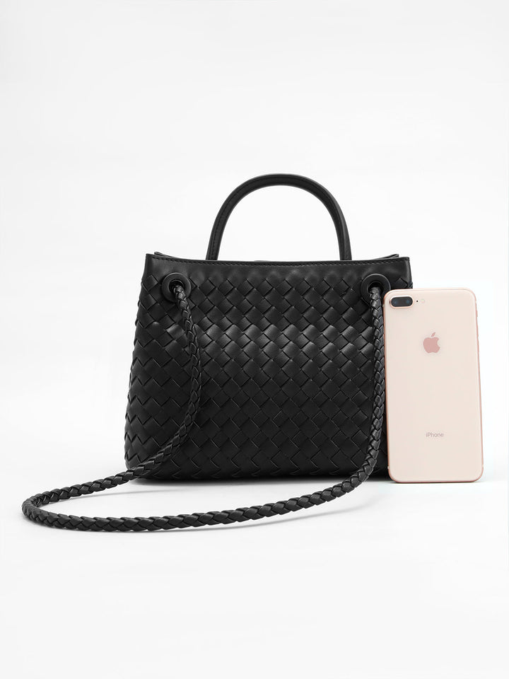 Structured women's top handle woven bag in black, highlighted by an elegant twist design, a stylish accessory.