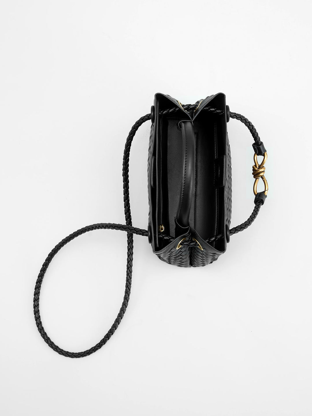 Fashionable black woven top handle bag for women, an elegant & structured handbag with a distinctive twist accent.