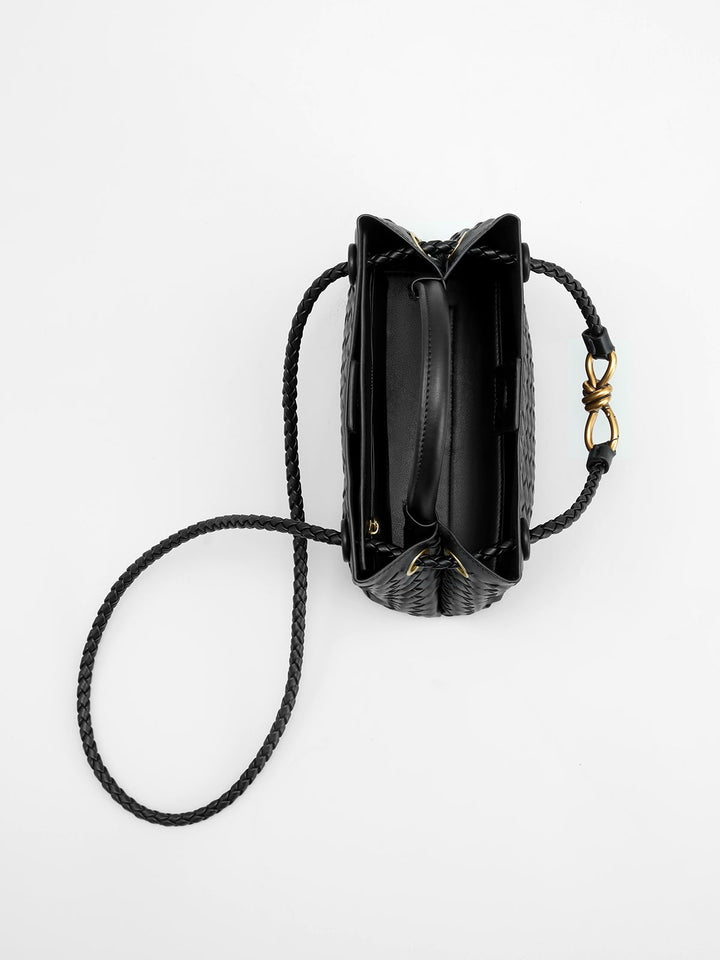 Fashionable black woven top handle bag for women, an elegant & structured handbag with a distinctive twist accent.
