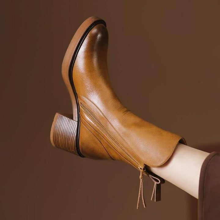 Side view of women's black leather ankle boots. Features a comfortable block heel & easy side zipper closure.